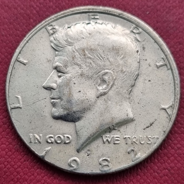 1982 Kennedy half dollar off-center strike error showing the design shifted with a blank crescent of unstruck metal visible